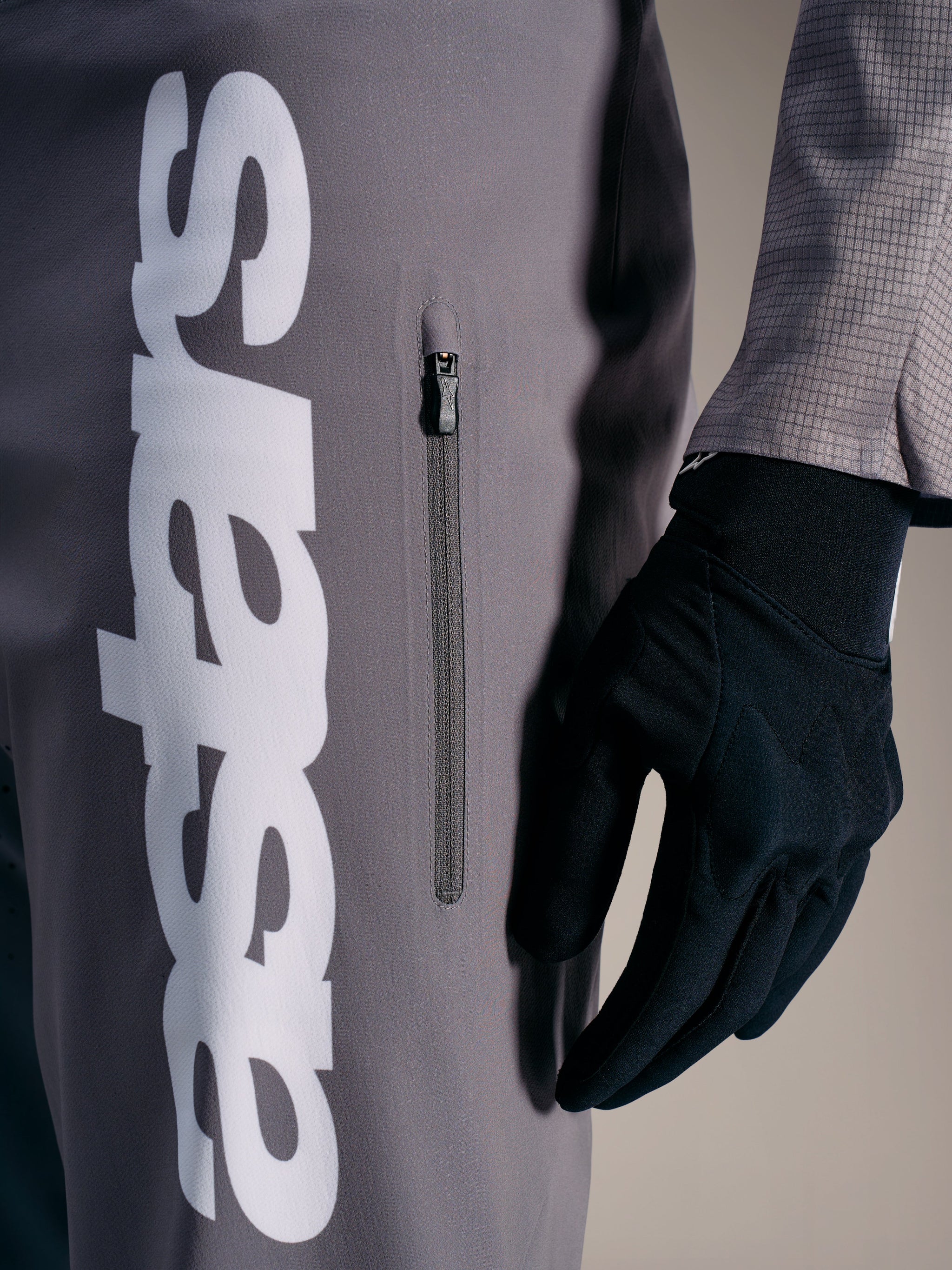 A-Supra Elite bukser i grå med hvidt Alpinestars-logo og lodret lynlåslomme, designet til MTB-racing.