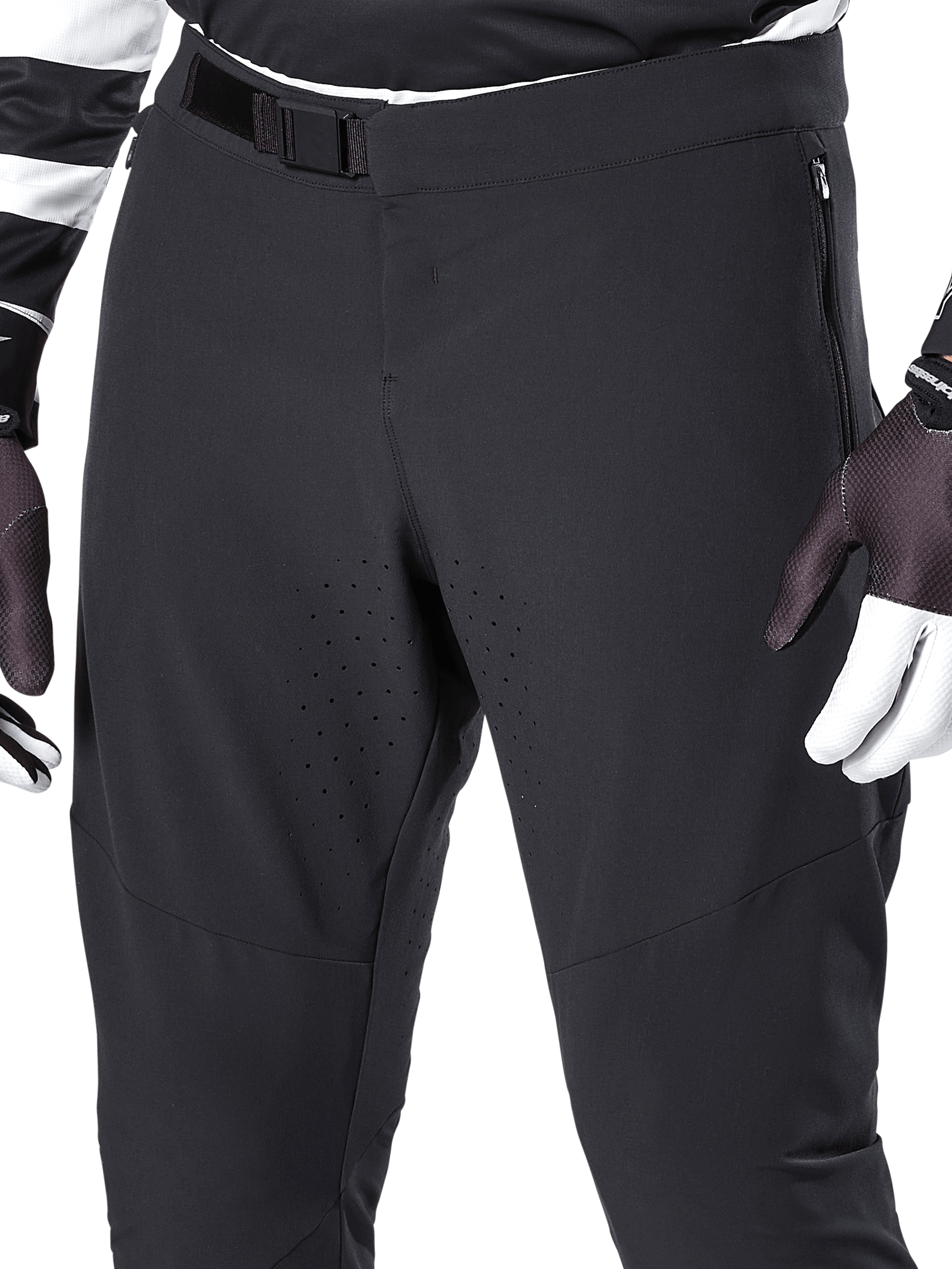 Alpinestars A-Aria Elite bukser, sorte mountainbike-bukser, nærbillede af fronttaljen og lårene med magnetisk spændelukning og laserskårne ventilationshuller, kombineret med cykelhandsker