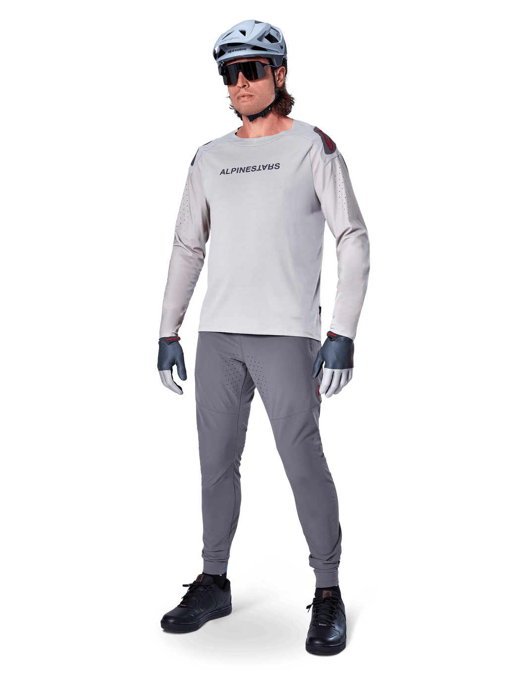 Alpinestars A-Aria Elite bukser, mørkegrå MTB-bukser, båret af en rytter med lysegrå langærmet jersey og grå hjelm, med laserskåret ventilation på lårene og en tætsiddende performance-pasform til mountainbike.