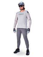 Alpinestars A-Aria Elite bukser, mørkegrå MTB-bukser, båret af en rytter med lysegrå langærmet jersey og grå hjelm, med laserskåret ventilation på lårene og en tætsiddende performance-pasform til mountainbike.