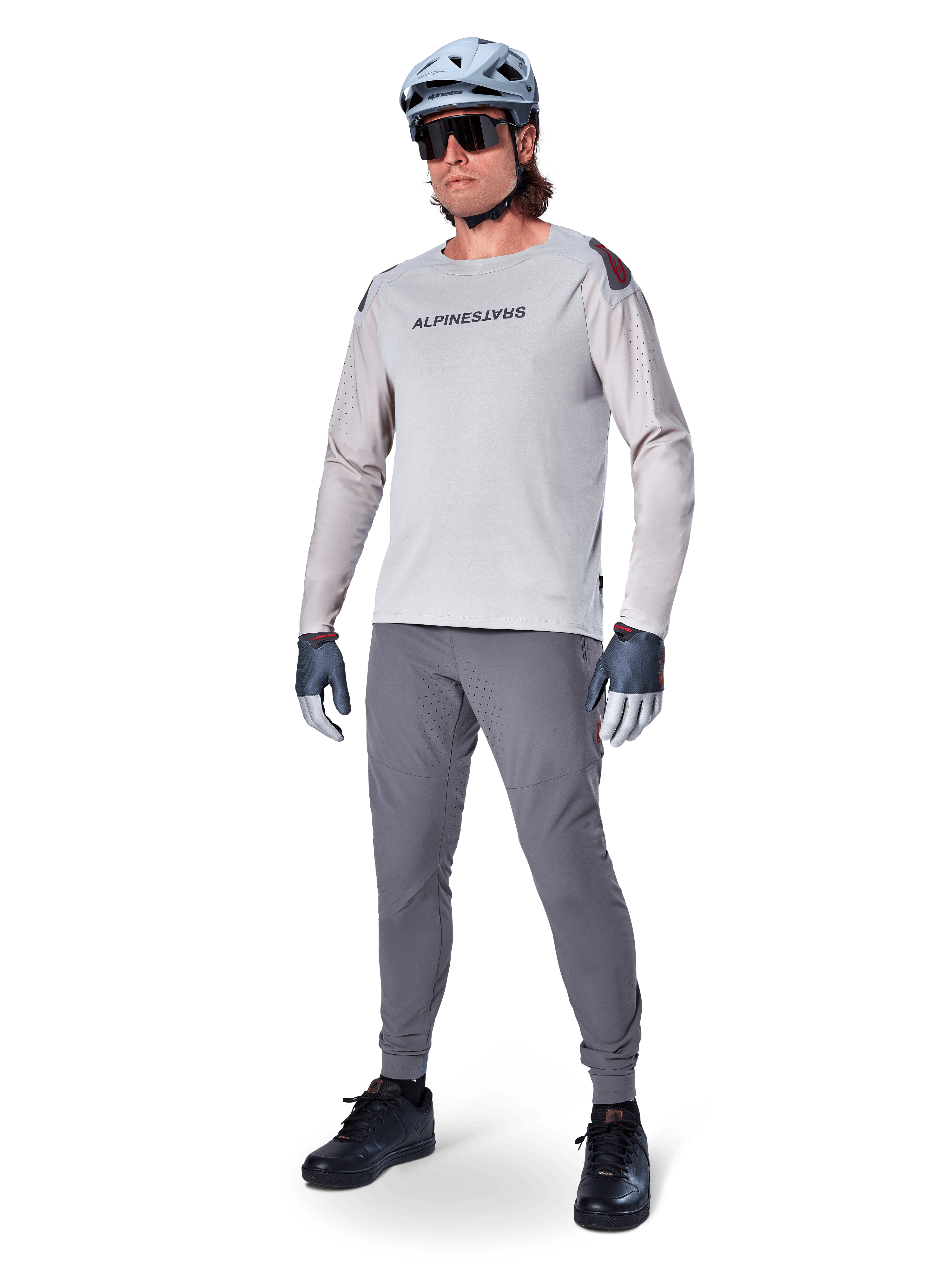 Alpinestars A-Aria Elite bukser, mørkegrå MTB-bukser, båret af en rytter med lysegrå langærmet jersey og grå hjelm, med laserskåret ventilation på lårene og en tætsiddende performance-pasform til mountainbike.