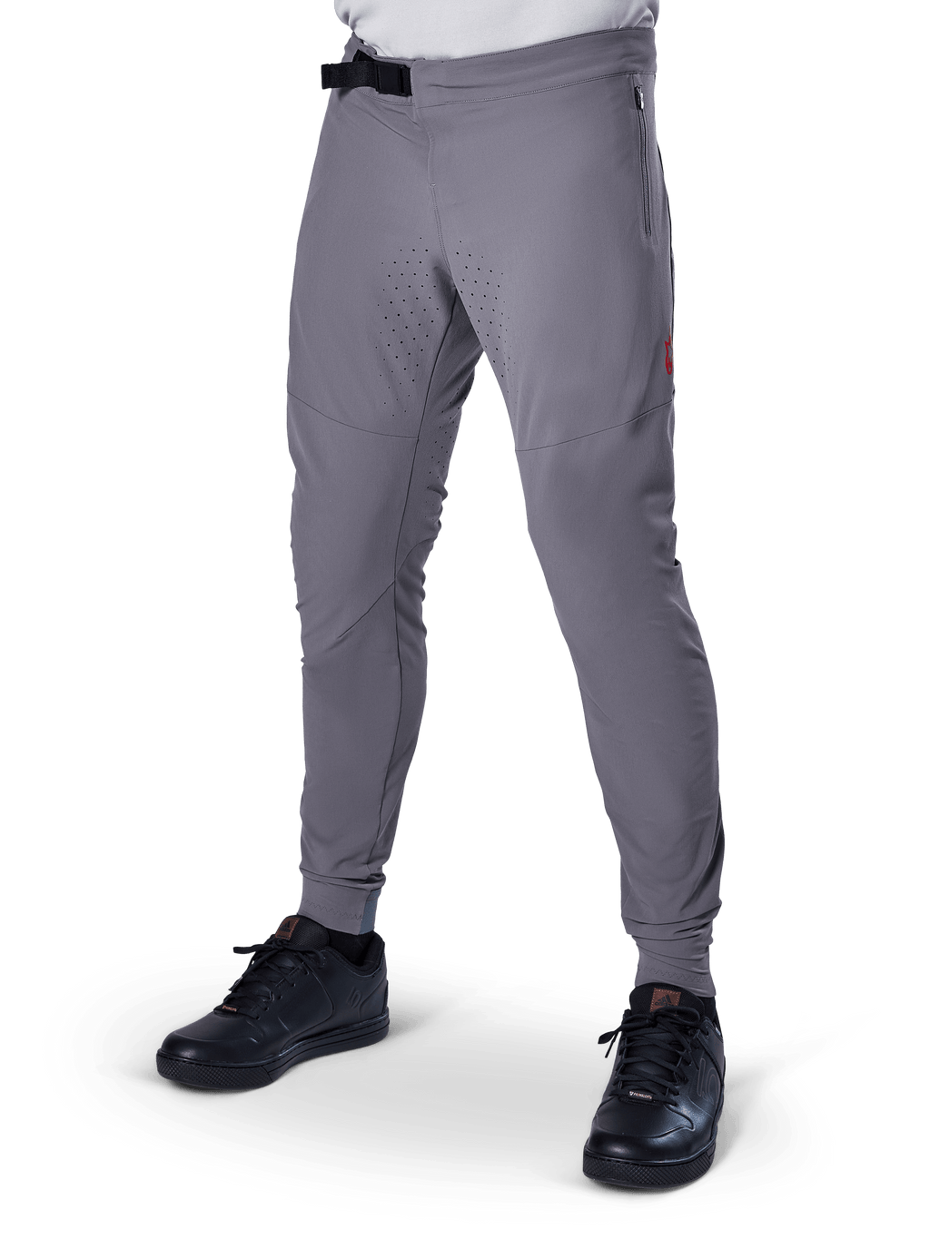 Alpinestars A-Aria Elite bukser, mørkegrå MTB-bukser, laserperforerede paneler på lårene, sort magnetisk spændelukning, lynlåslomme, rød logodetalje, tætsiddende performance-pasform, vist med sorte sko