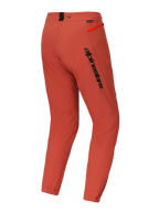 Alpinestars A-Dura Elite bukser, mountainbike (MTB) bukser, mørk orange, set skråt bagfra med markant sort Alpinestars-branding på låret, stærk orange lynlåsdetalje på hoften og elastiske ankelmanchetter, teknisk performance-cykeludstyr