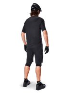 Set bagfra af en mountainbiker iført Alpinestars A-Aria Elite Shorts i sort, kombineret med en matchende sort kortærmet jersey, sort hjelm, handsker og MTB-sko, der viser et komplet performance-outfit til off-road cykling.