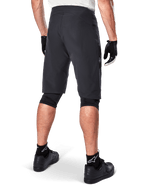 Alpinestars A-Aria Shorts, mountainbike-shorts, sort, set bagfra, viser performance-pasform og rent design, båret med sorte handsker og sokker med det hvide Astars-logo, teknisk cykeltøj til off-road kørsel
