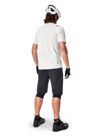 Mountainbiker set bagfra iført Alpinestars A-Aria Shorts i sort, hvid kortærmet performance-trøje, hvid hjelm, sorte handsker og sorte mountainbike-sko, cykeludstyr til trailkørsel