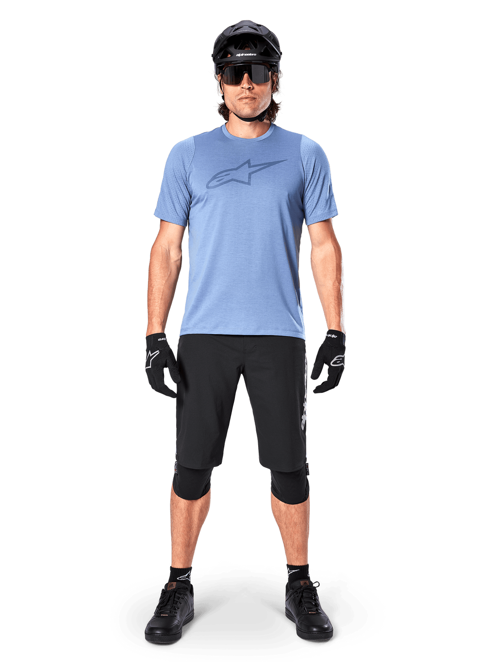 Alpinestars A-Dura Elite Shorts, Black Mountain Bike Shorts, worn with a light blue t-shirt, black helmet, sunglasses, and knee pads, professional off-road cycling apparel