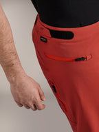 Alpinestars A-Dura Elite Shorts, mørkeorange, nærbillede af sideprofil med burrebåndsjustering i taljen, Cordura®-logo og lynlåslomme på siden, premium mountainbike-shorts