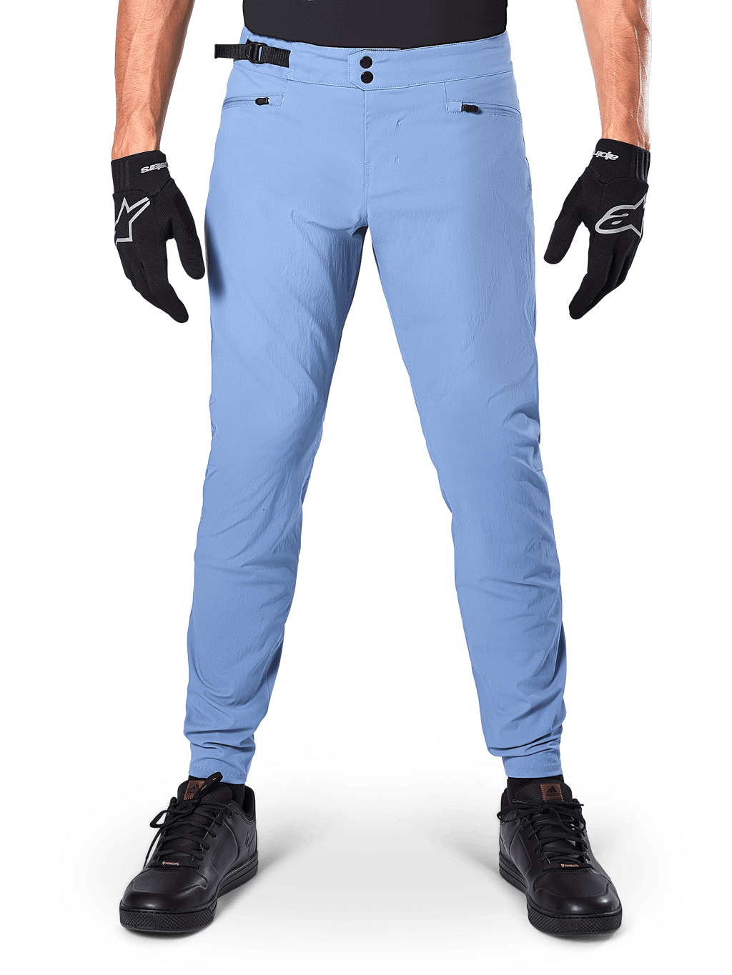 Alpinestars A-Dura bukser, MTB-bukser, Infinity Blue, lyseblå mountainbike-bukser med dobbelt trykknaplukning og lynlåslommer, båret med sorte handsker og sorte sko, almindelig pasform med elastiske manchetter