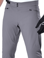 Alpinestars A-Dura bukser, MTB-bukser, mørkegrå, nærbillede af taljeområdet med dobbelt tryklåslukning, justerbar sideklemme og lynlåslommer, holdbart strækstof til mountainbike