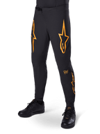 Alpinestars A-Supra Race bukser, sorte med orange stjernegrafik, MTB-racerbukser med laserperforeret ventilation og spænde i taljen, tætsiddende performance-pasform til off-road cykling