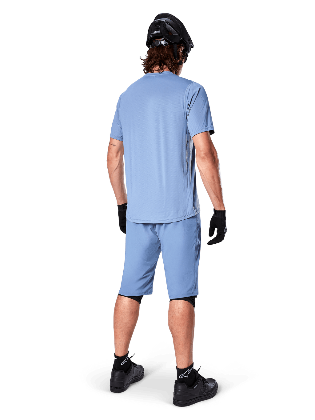 Set bagfra af en mountainbiker iført Alpinestars A-Dura shorts i Infinity Blue, matchende kortærmet trøje, sort hjelm, sorte handsker og sorte sko, koordineret performance-udstyr til MTB trail-kørsel