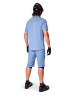 Set bagfra af en mountainbiker iført Alpinestars A-Dura shorts i Infinity Blue, matchende kortærmet trøje, sort hjelm, sorte handsker og sorte sko, koordineret performance-udstyr til MTB trail-kørsel