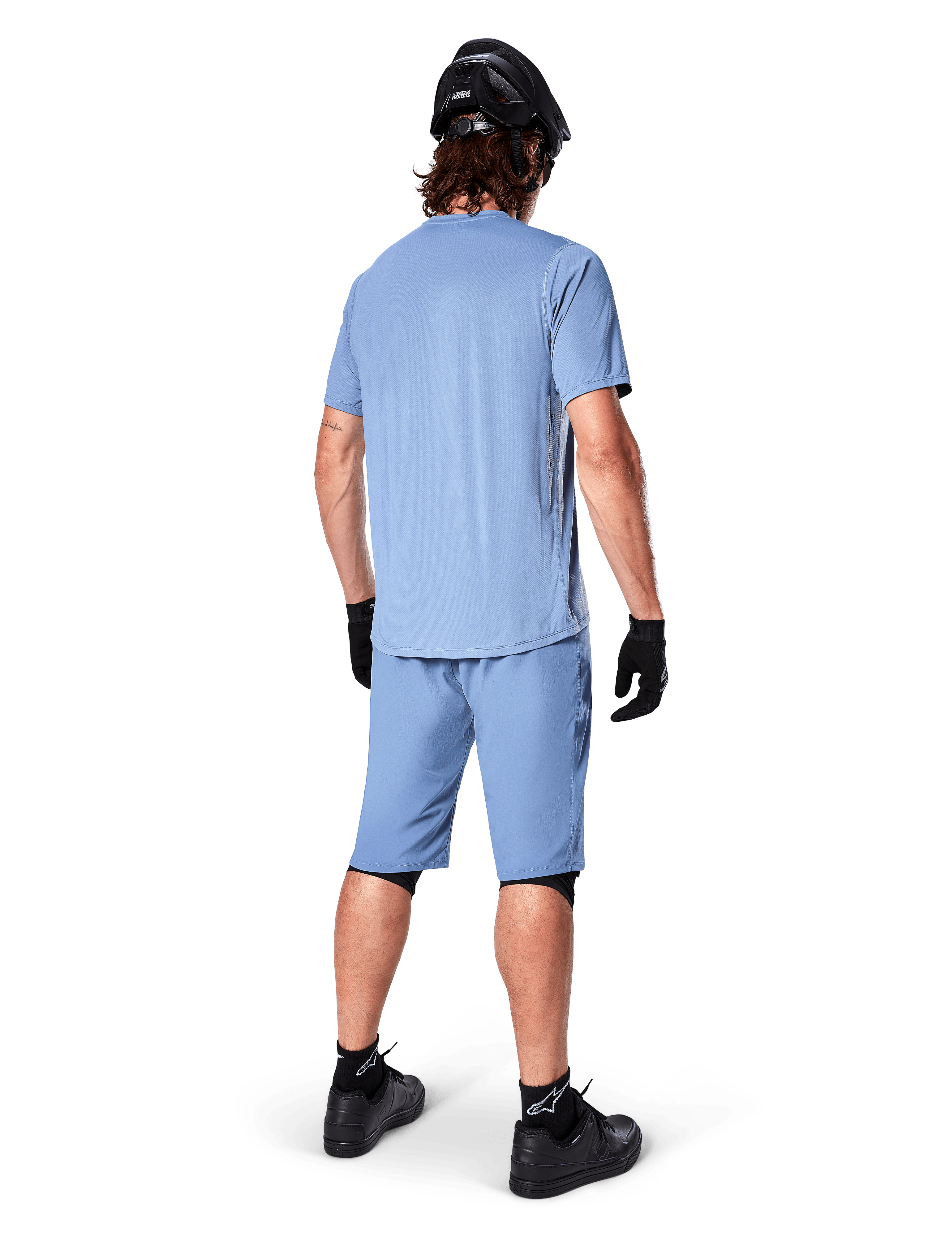 Set bagfra af en mountainbiker iført Alpinestars A-Dura shorts i Infinity Blue, matchende kortærmet trøje, sort hjelm, sorte handsker og sorte sko, koordineret performance-udstyr til MTB trail-kørsel