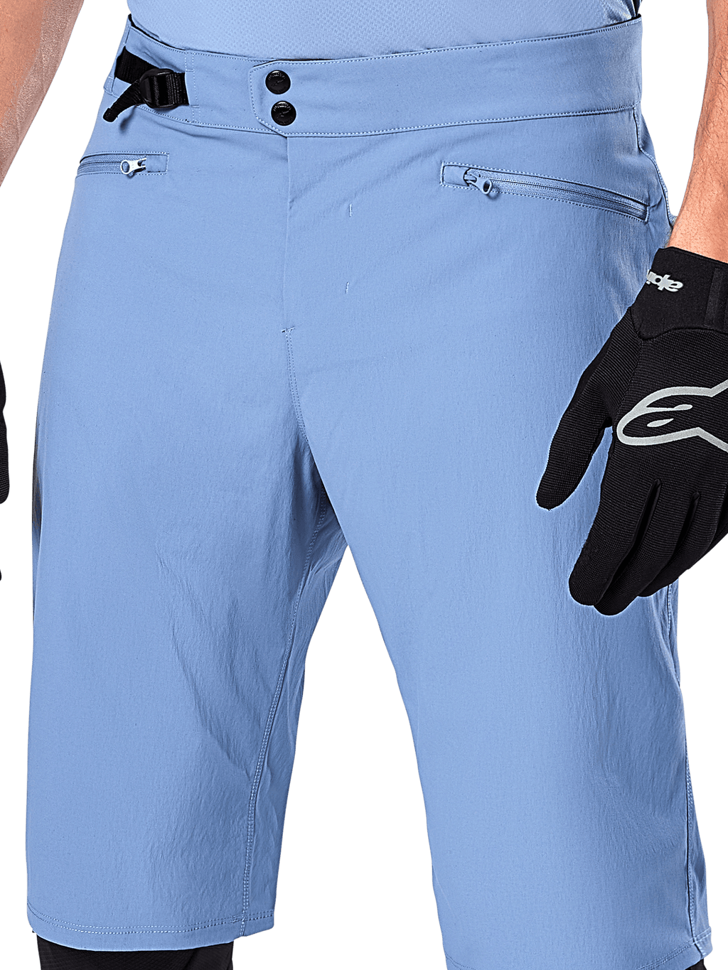Alpinestars A-Dura Shorts, Infinity Blue mountainbike-shorts, nærbillede af taljen med dobbelt snaplukning, justerbar sidejustering og lynlåslommer med mesh-foring, båret med en sort Alpinestars-handske