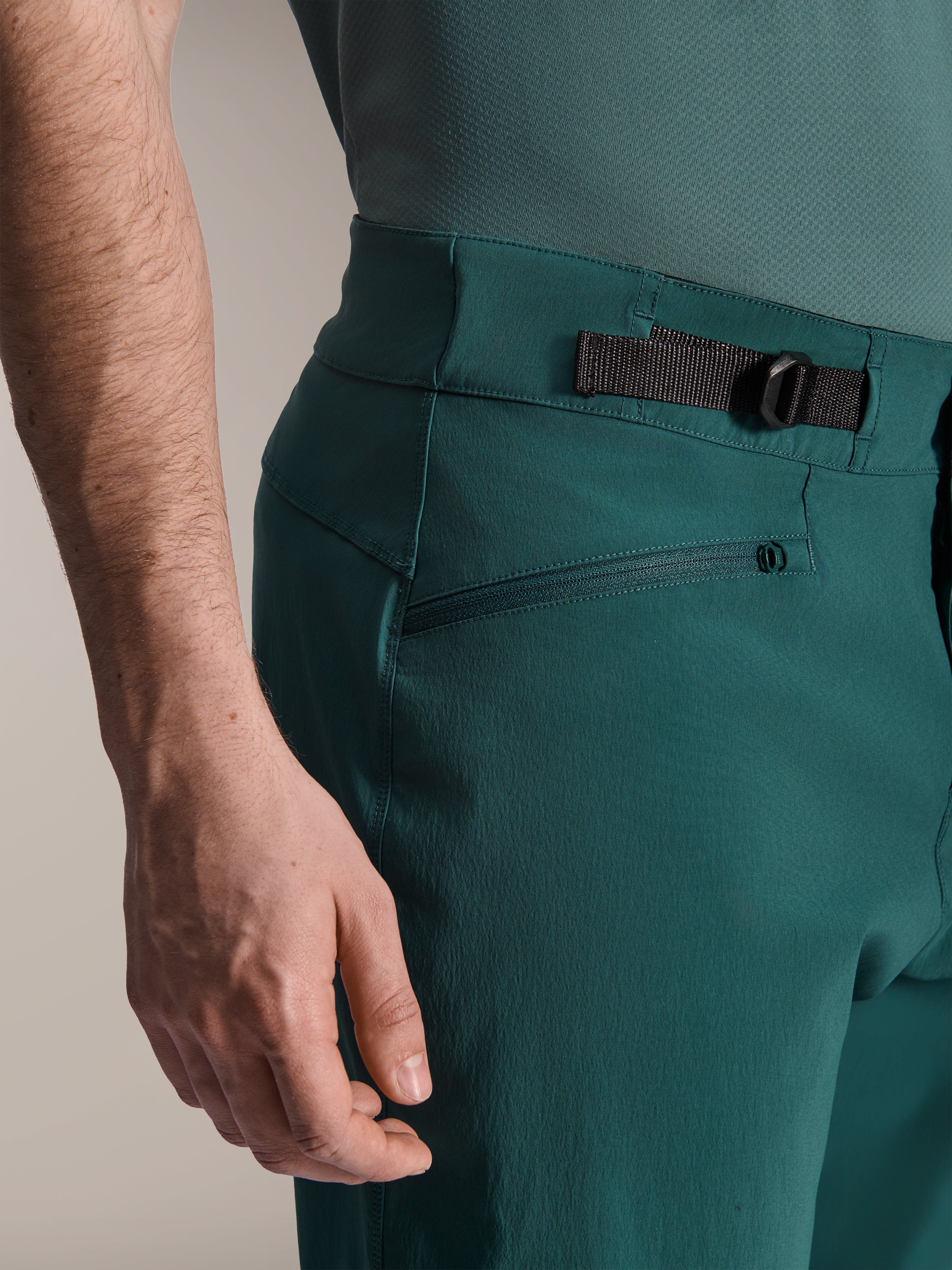 Alpinestars A-Dura Shorts, mørk fyrregrøn, nærbillede af den justerbare taljejustering i siden og lynlåslomme, slidstærkt performance-udstyr til mountainbike