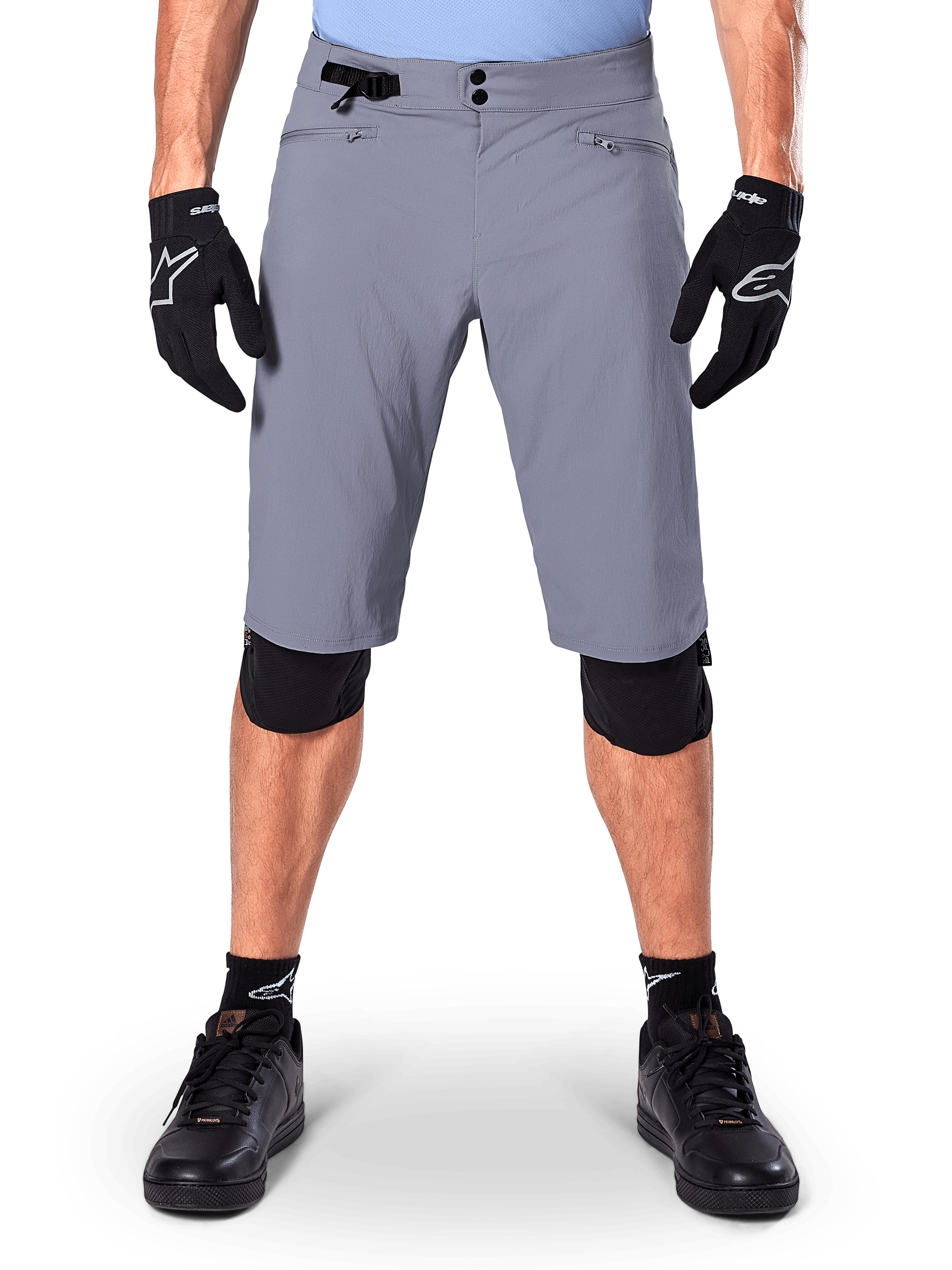 Alpinestars A-Dura Shorts, mountainbike-shorts, mørkegrå, båret med sorte Alpinestars handsker og knæbeskyttere, med dobbelt trykknaplukning og lynlåslommer med mesh-foring, slidstærkt 2-vejs strækstof til off-road cykling