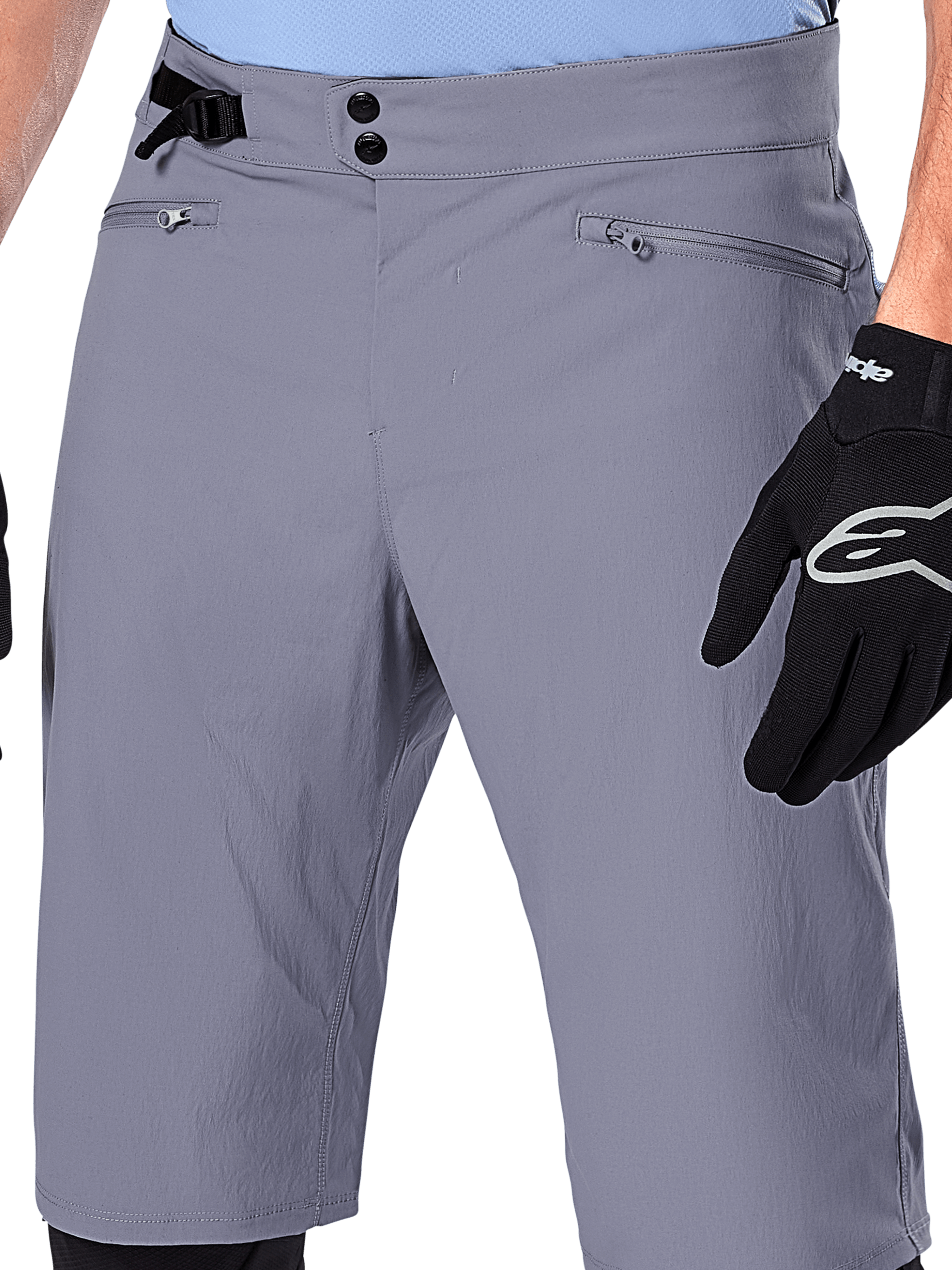Alpinestars A-Dura Shorts, MTB-shorts, mørkegrå, nærbillede af taljen med dobbelt trykknaplukning, sidejustering af taljen og lynlåslommer, kombineret med sorte cykelhandsker, holdbart mountainbike-tøj
