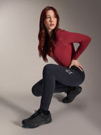 Alpinestars Stella A-Dura termobukser, MTB-bukser til damer, sort, båret af en model siddende på hug med en bordeauxrød langærmet top og sorte cykelsko, med et hvidt stjernelogo på låret, holdbar og varm konstruktion til terrænkørsel i koldt vejr