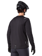 Alpinestars A-Dura Thermal Jersey, langærmet mountainbike-trøje, sort, set bagfra som viser forlænget drop tail, små refleksdetaljer og branding ved sømmen, båret med en sort hjelm og handsker til cykling i koldt vejr