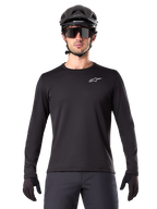 Alpinestars A-Dura Termotrøje, sort langærmet mountainbike-trøje, vist med en sort hjelm og store solbriller, med et lille hvidt Alpinestars-logo på brystet, regular fit, MTB-cykeltøj
