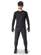 Alpinestars A-Dura Termotrøje, sort langærmet mountainbike-trøje, kombineret med mørkegrå bukser, sorte handsker, sort hjelm og solbriller, hvidt Alpinestars-logo på brystet, koordineret outfit til mountainbike-kørsel i koldt vejr