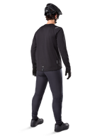 Alpinestars A-Dura Thermal Jersey, langærmet cykeltrøje til mænd, sort, set bagfra på model iført en sort MTB-hjelm, mørkegrå bukser og sorte handsker, professionelt mountainbike-tøj til koldt vejr
