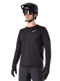 Alpinestars A-Dura Thermal Jersey, sort langærmet mountainbike-trøje, hvidt logo på brystet, båret med sort hjelm og handsker, strømlinet sporty design til trailkørsel