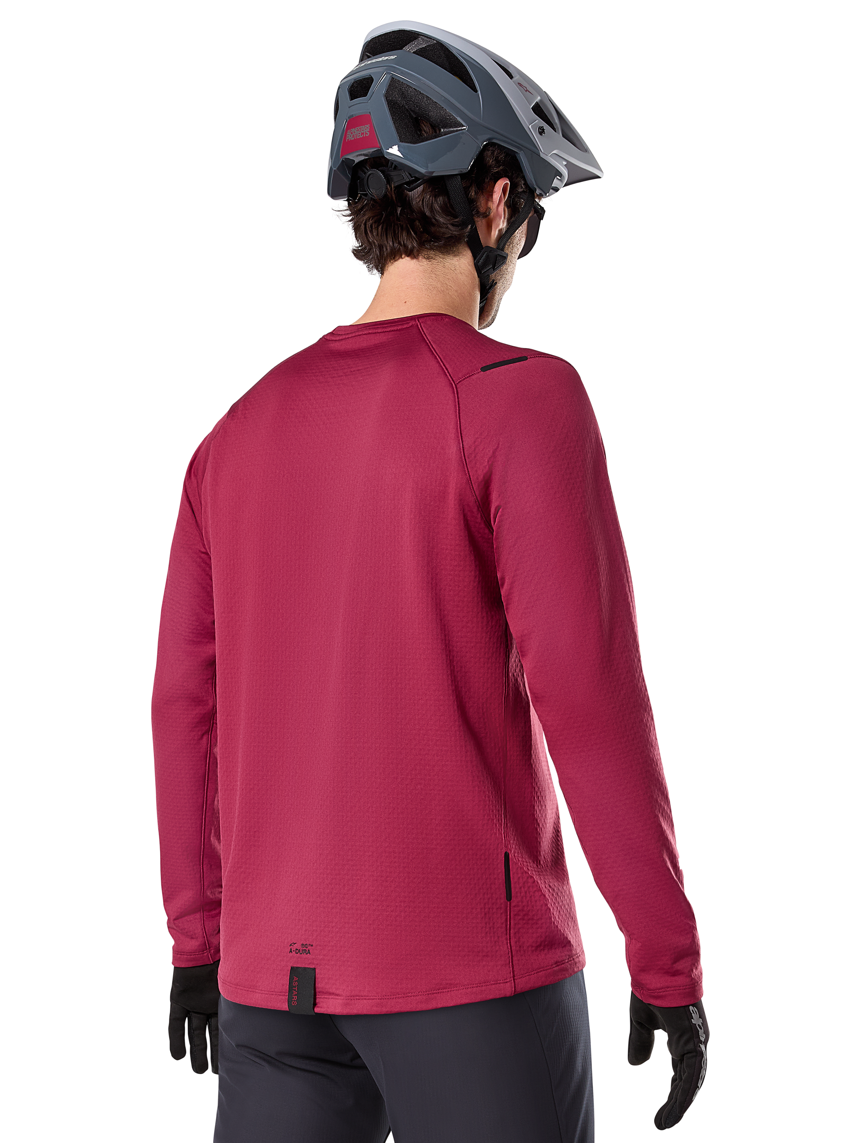 Alpinestars A-Dura Thermal trøje, langærmet mountainbike-trøje, bordeaux, set bagfra på model iført grå MTB-hjelm og sorte handsker, med forlænget rygstykke og små logodetaljer, designet til terrænkørsel i koldt vejr