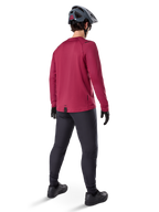 Alpinestars A-Dura Thermal Jersey, vinrød langærmet cykeltrøje, set bagfra, båret med sorte mountainbike-bukser og en grå hjelm, med en forlænget drop tail-kant for dækning bagtil, mountainbike-udstyr til koldt vejr