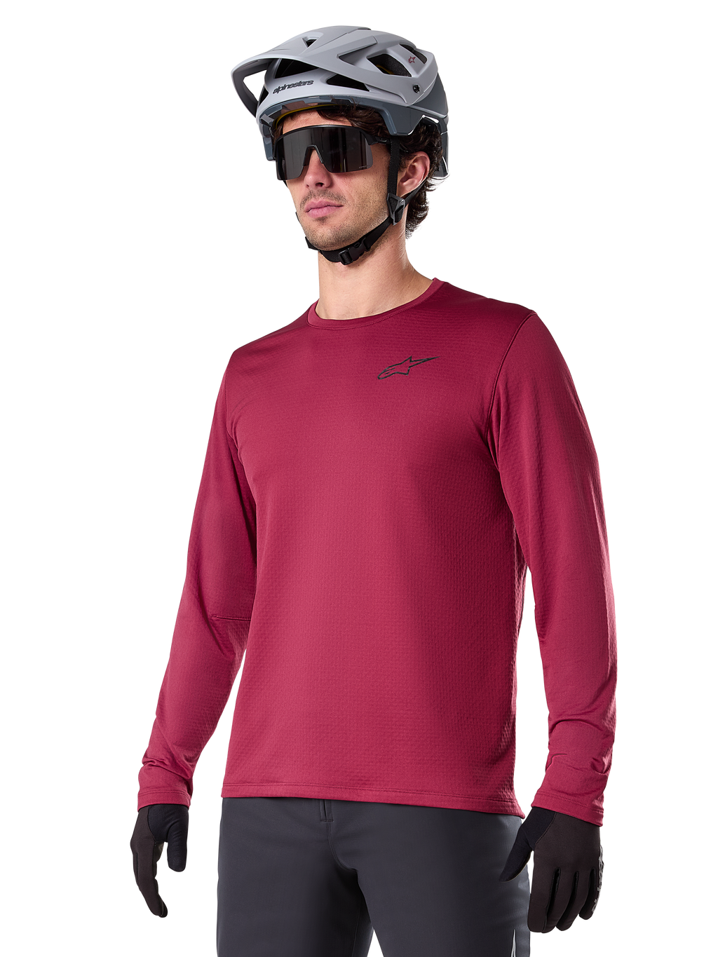 Alpinestars A-Dura Thermal Jersey, langærmet mountainbike-trøje, burgundy-rød, med isolerende fleece-for og lille sort logo på brystet, vist med grå hjelm, sorte solbriller og sorte handsker, designet til cykling i koldt vejr