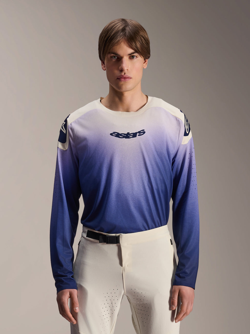 Alpinestars A-Aria Polartec Maker Elite trøje, langærmet MTB-trøje, Baja Blue med hvid-til-blå gradient, båret af en model med hvide bukser, med mørkeblåt logo på brystet og laserperforeringer på ærmerne, performance mountainbike-beklædning