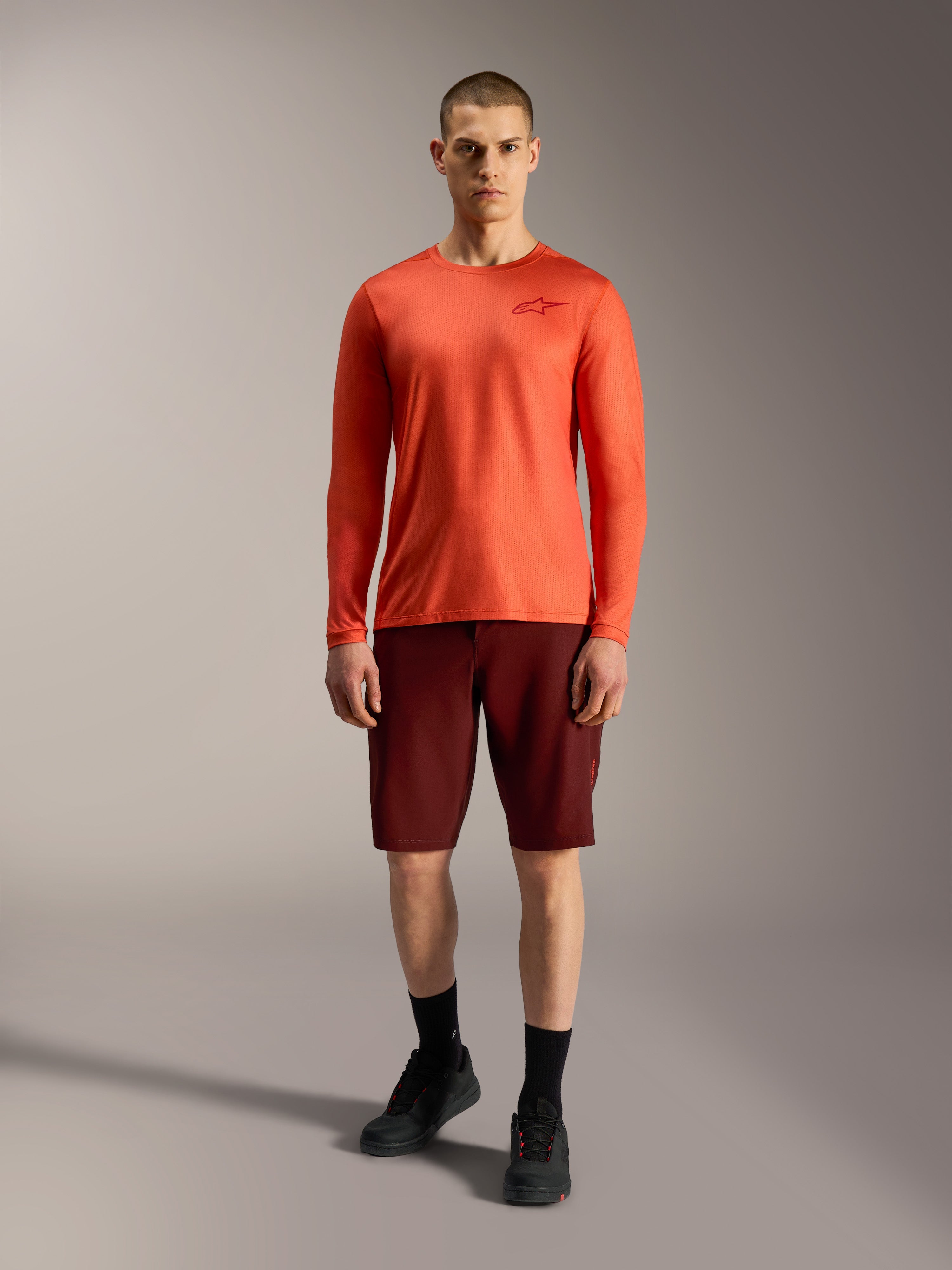 Alpinestars A-Dura Ride Shorts i bordeaux og orange trøje, designet til slidstærk mountainbike-performance.