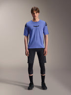 Alpinestars A-Aria Lite Short, herre mountainbike shorts, sort, båret med lys lilla kortærmet jersey og sorte knæbeskyttere, performance MTB-beklædning