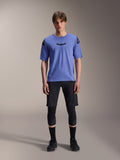 Alpinestars A-Aria Elite Shorts, MTB mountainbike-shorts, Black Titanium, båret med blå kortærmet jersey, knæbeskyttere og sorte cykelsko, fuldkropsstudiebillede, teknisk mountainbike-beklædning