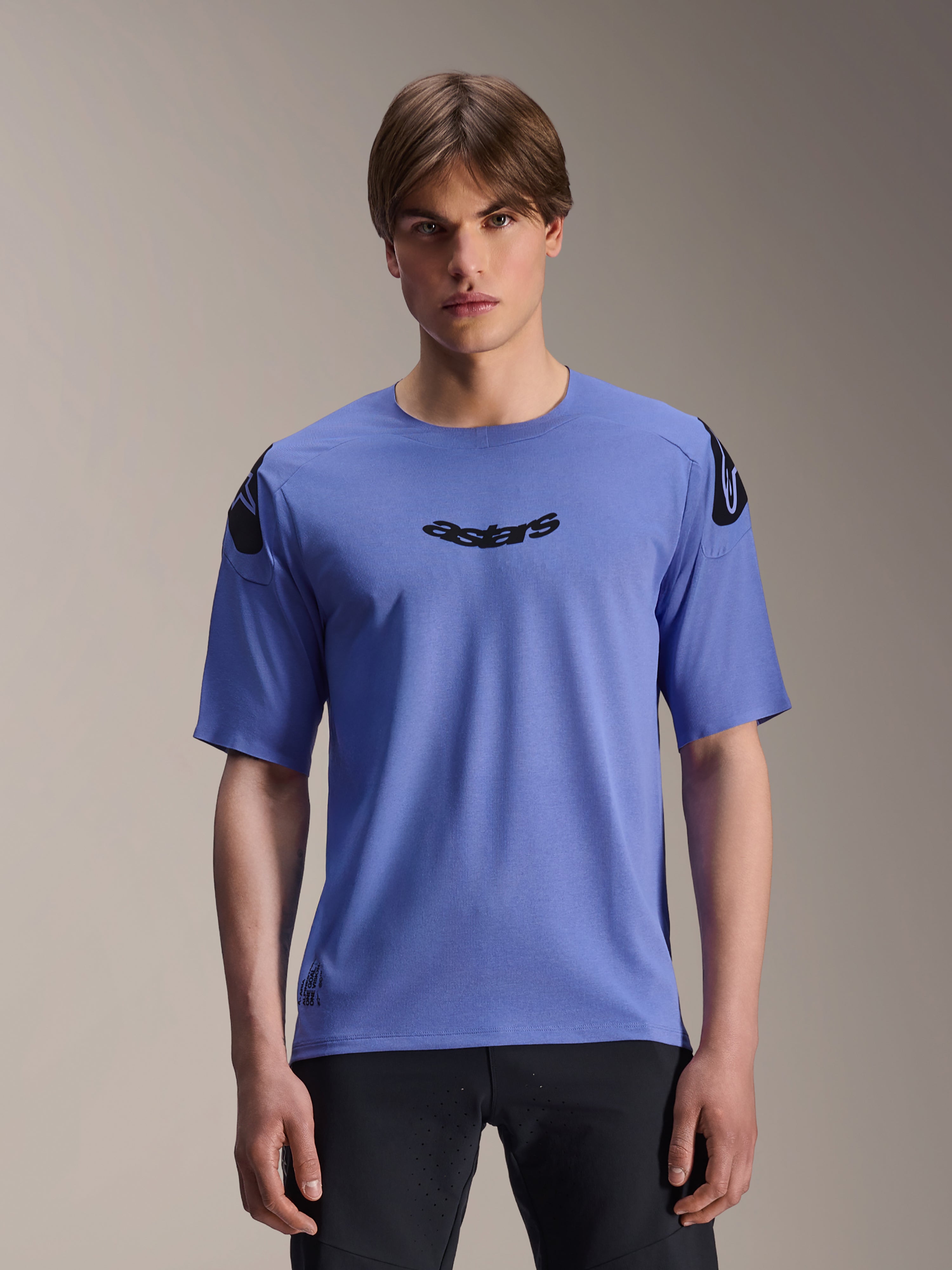 Alpinestars A-Aria Polartec Elite Jersey, kortærmet MTB-trøje, Baja Blue, båret af en mandlig model, med sort 'astars'-navnetræk på brystet og logoer på skuldrene, performance-beklædning til mountainbike.