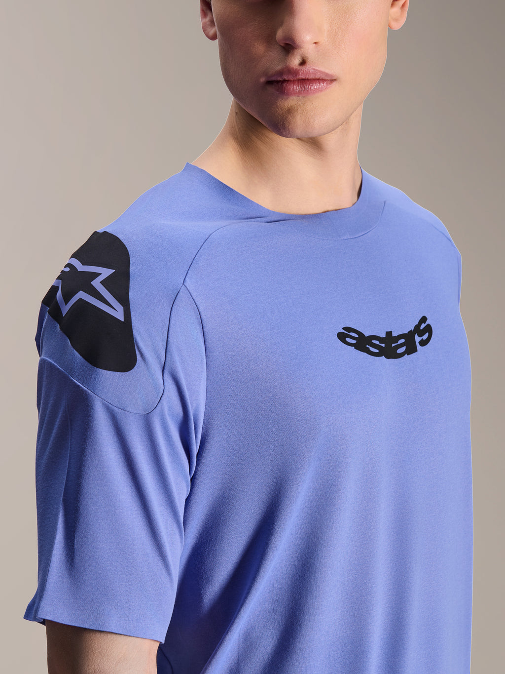 Alpinestars A-Aria Polartec Elite Jersey, kortærmet mountainbike-jersey, Baja Blue, nærbillede af bryst og skulder med sort astars-logo og skuldergrafik, teknisk fugttransporterende materiale til off-road cykling