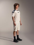 Alpinestars A-Aria Polartec Elite kortærmet jersey, ecru med sorte skulderpaneler og logo, båret af en model med matchende shorts og sorte sko, performance mountainbike-tøj til terrænkørsel.