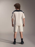 Alpinestars A-Aria Elite Shorts og A-Aria Polartec Elite SS Jersey, Ecru med sorte skulderpaneler, model set bagfra i mountainbike-udstyr, stylet med sorte strømper og sko