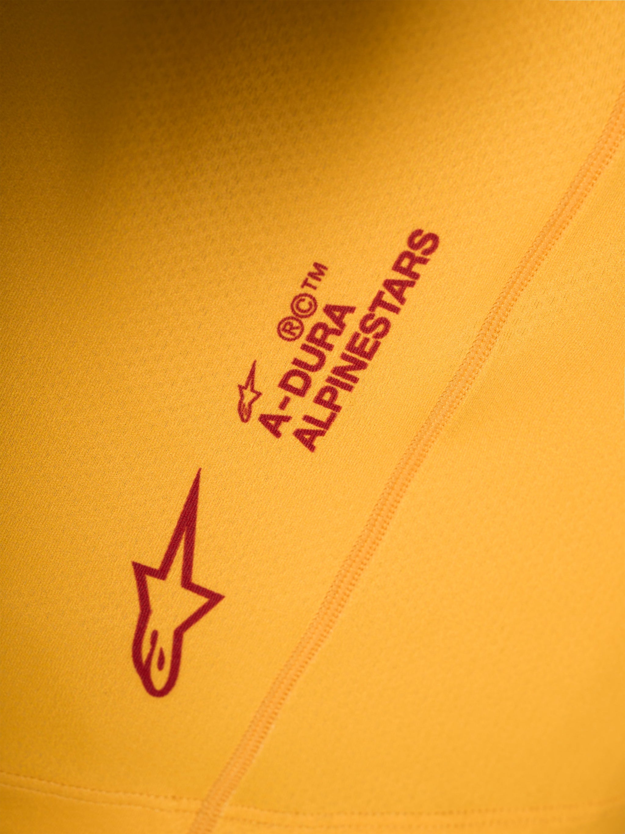 Orange A-Dura Ride trøje med rødt Alpinestars Astars-logo og ordmærke trykt på strækbart stof.