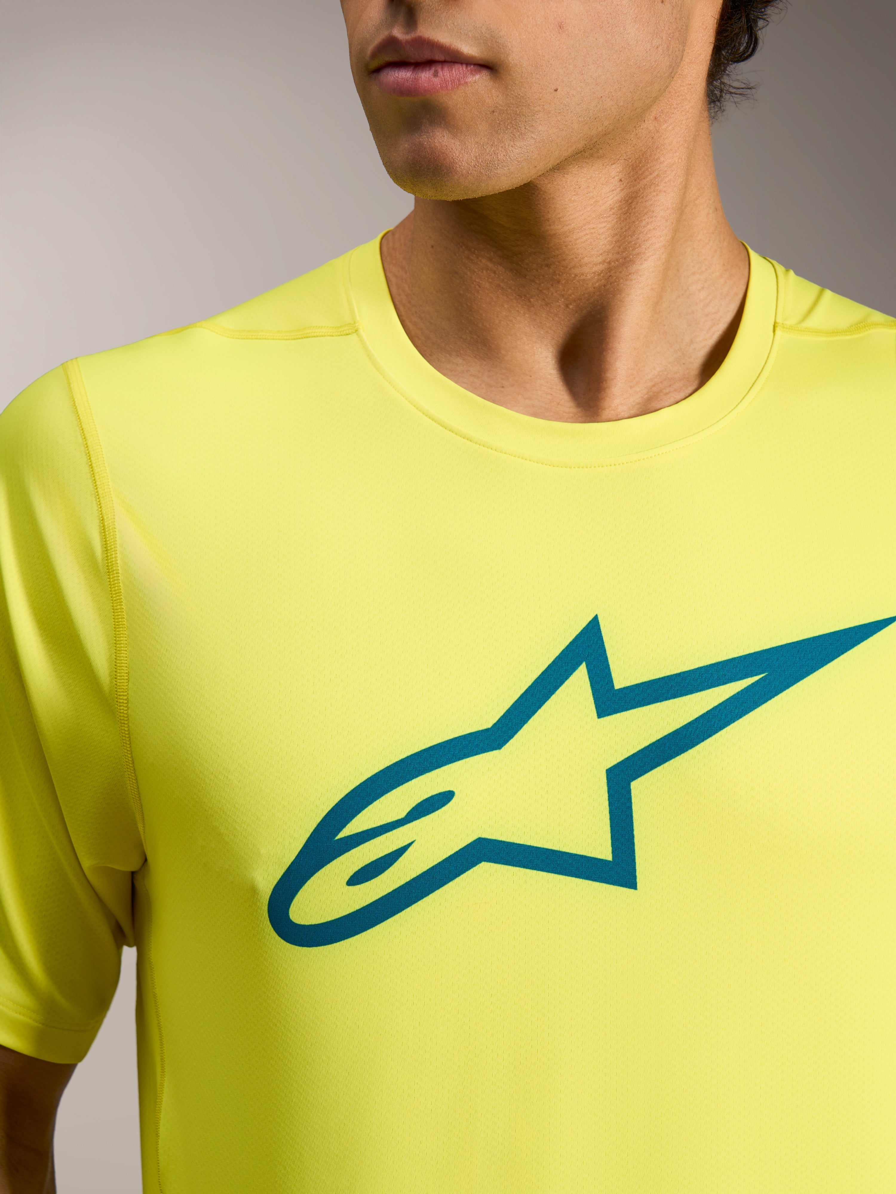 Gul Fluo A-Dura Ride kortærmet trøje med teal Astars-logo på brystet, letvægts teknisk MTB-tøj.