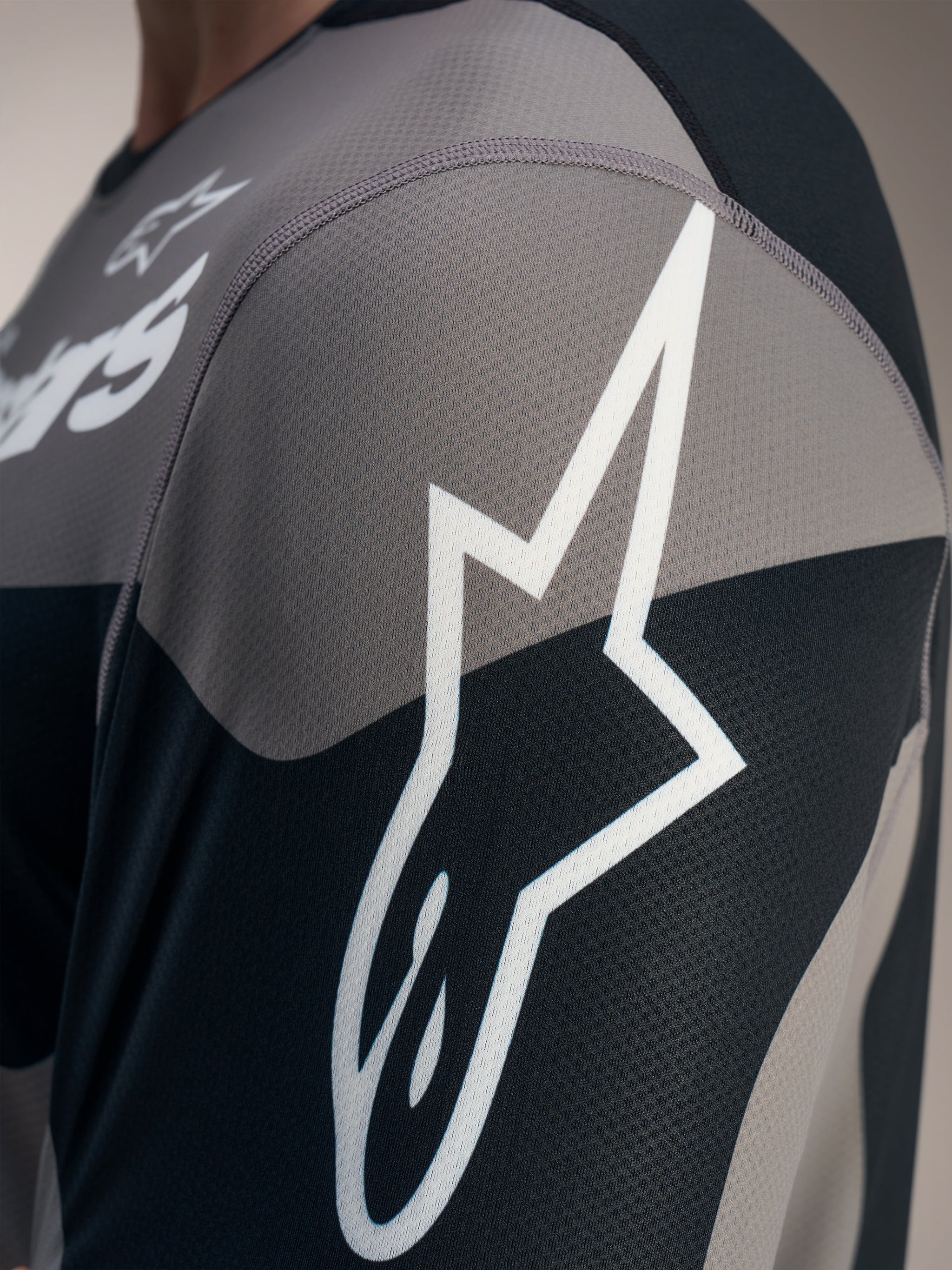 Grå Alpinestars A-Dura Race langærmet trøje med hvidt Astars-logo på tekstureret, teknisk jacquard mesh-stof.
