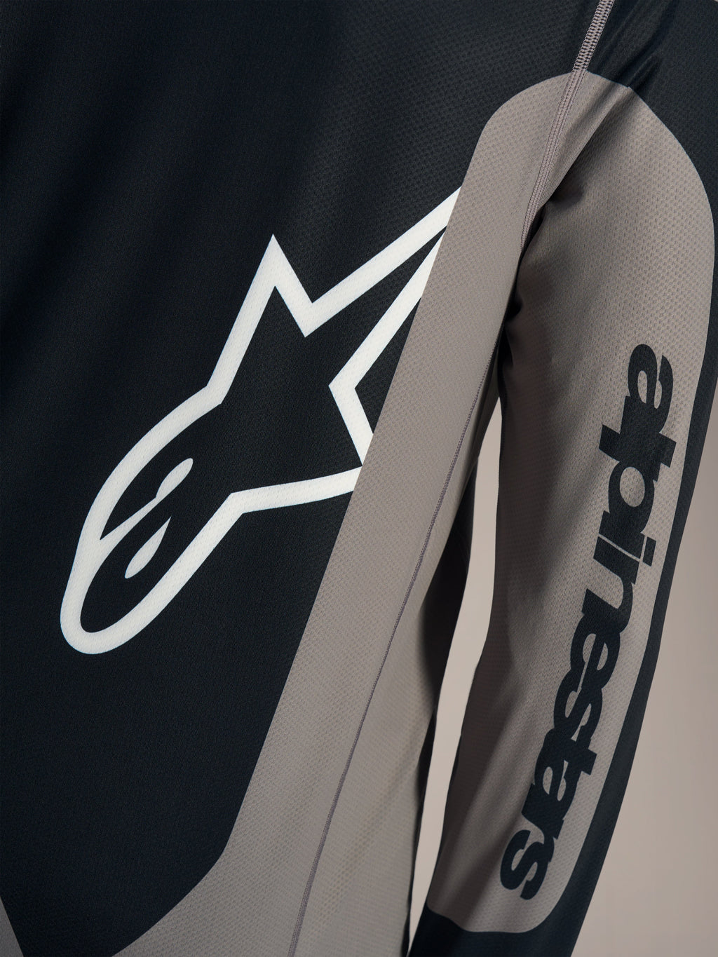 Grå Alpinestars A-Dura Race trøje med hvidt Astars-brystlogo og sort tekst på ærmet, åndbart mountainbike-tøj.