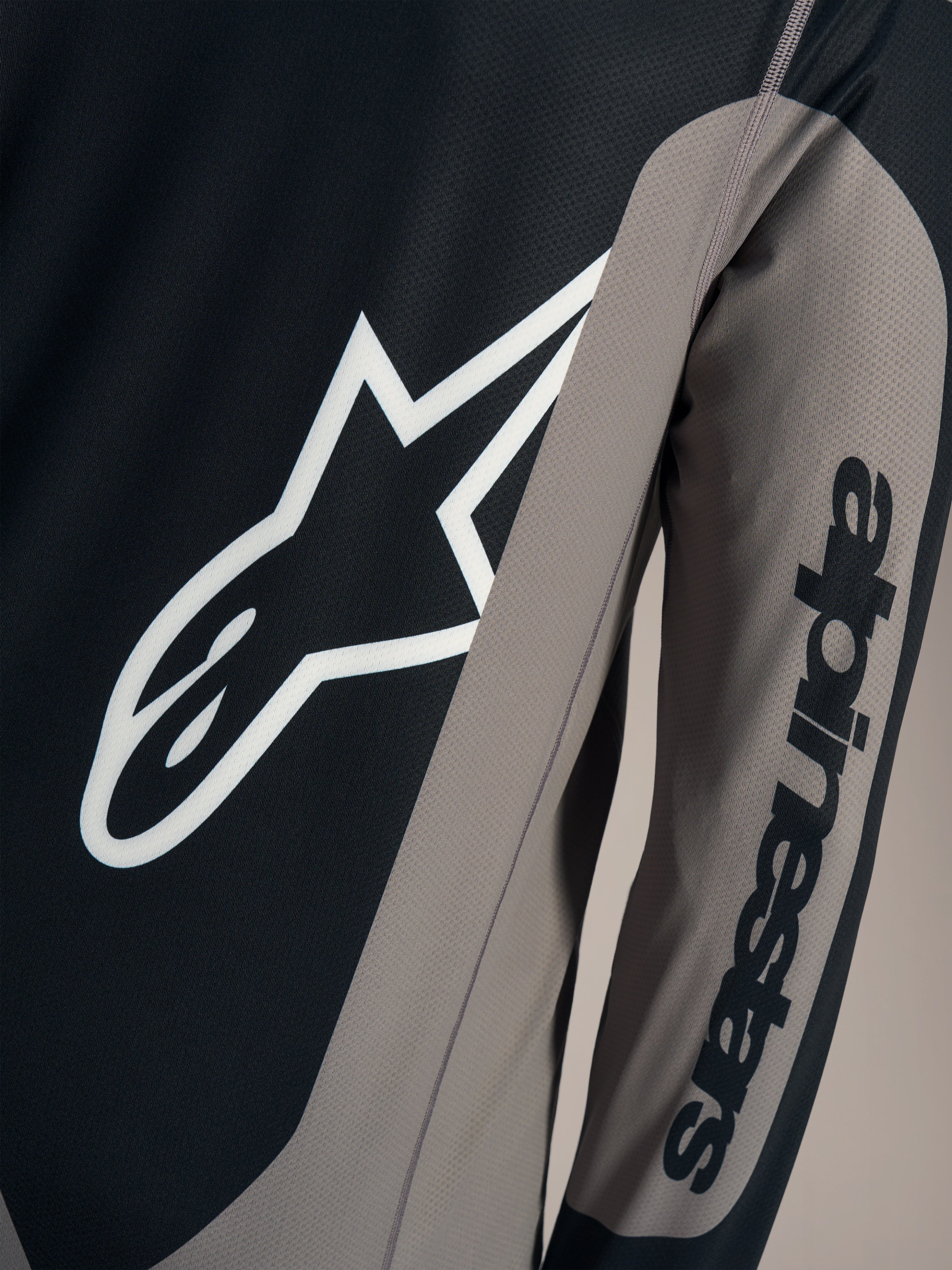 Grå Alpinestars A-Dura Race trøje med hvidt Astars-brystlogo og sort tekst på ærmet, åndbart mountainbike-tøj.