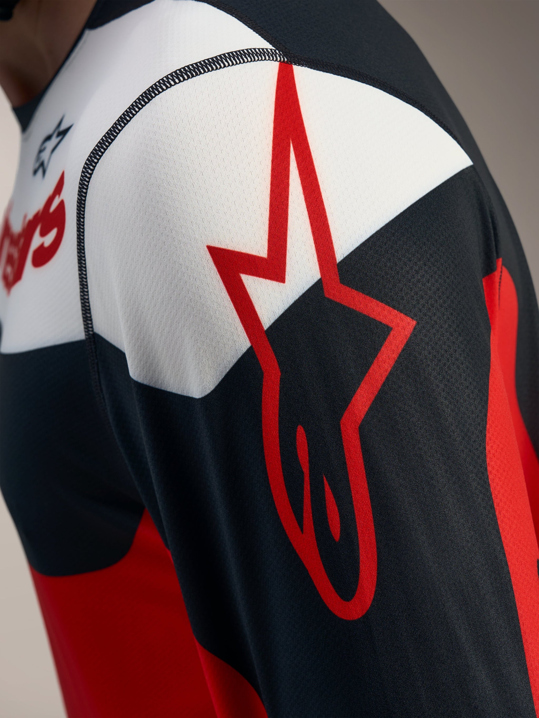 Rød og sort A-Dura Race langærmet trøje, detalje med Alpinestars stjerne-logo på åndbart jacquard-meshstof.