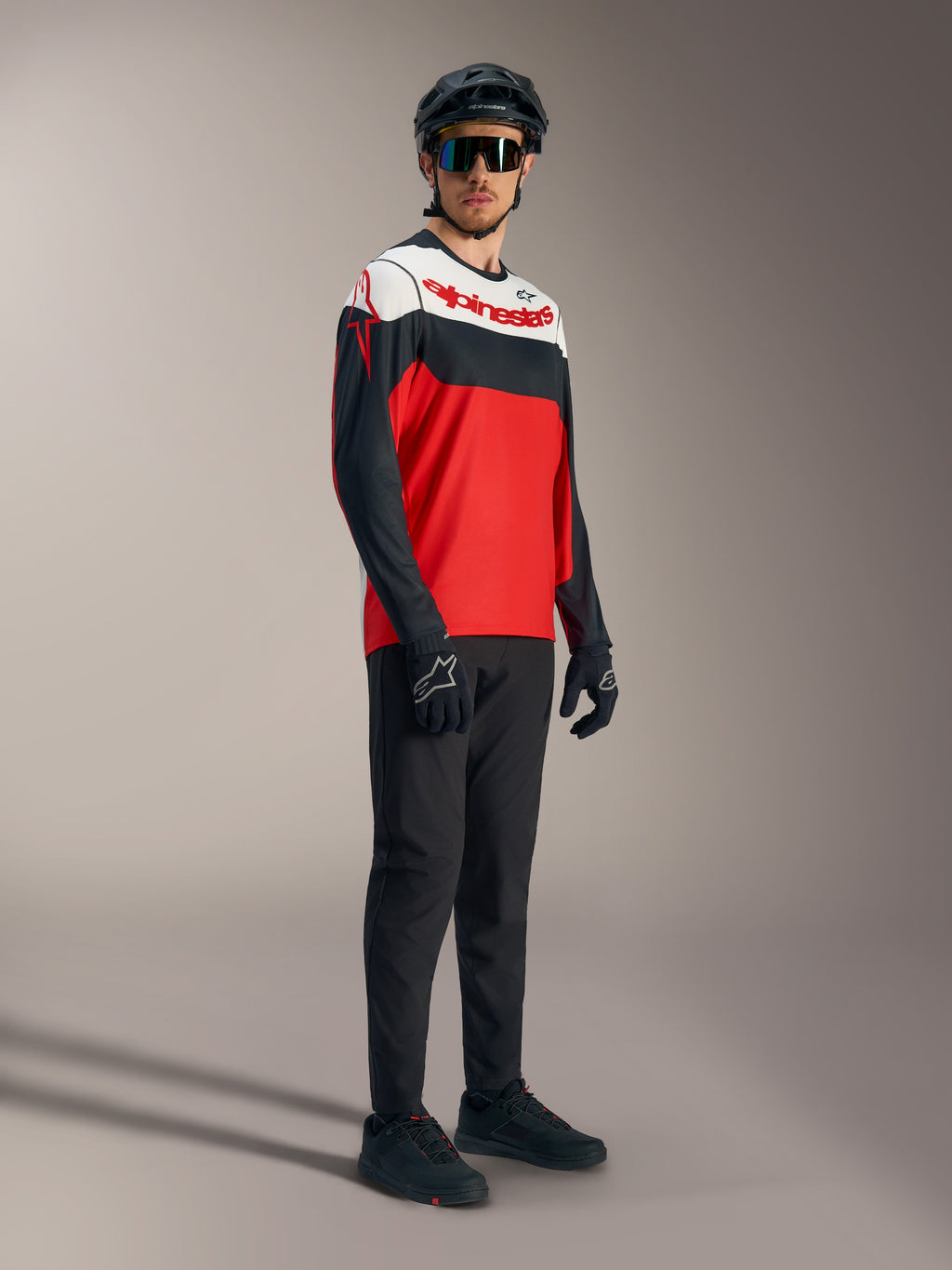 A-Dura Race langærmet trøje i rød, hvid og sort med markante logoer, stylet med professionelt mountainbike-udstyr.