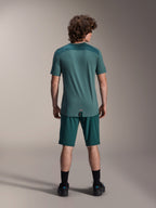 Alpinestars A-Dura Lipan kortærmet jersey i Silver Pine, set bagfra, der viser de teksturerede jacquard-skulderpaneler og drop tail-kant, båret med matchende mørkegrønne mountainbike-shorts og sort fodtøj.