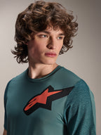Alpinestars A-Dura Lipan jersey, kortærmet MTB-trøje, Silver Pine, fremtrædende rødt og sort Astars-logo på brystet, teksturerede jacquard-ærmer, tæt portræt af model iført teknisk cykeltøj