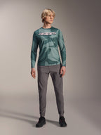 Alpinestars A-Dura Hollow Camo langærmet trøje, Silver Pine Camo med grønt camouflagemønster, stort hvidt "astars"-logo på brystet, båret med grå tekniske bukser og sorte cykelsko, højtydende MTB-udstyr