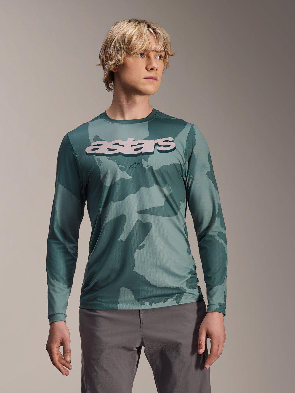 Alpinestars A-Dura Hollow Camo langærmet trøje, MTB-trøje, Silver Pine Camo grønt camouflagemønster, stort lysegråt astars-logo på brystet, vist med grå bukser, højtydende mountainbike-beklædning